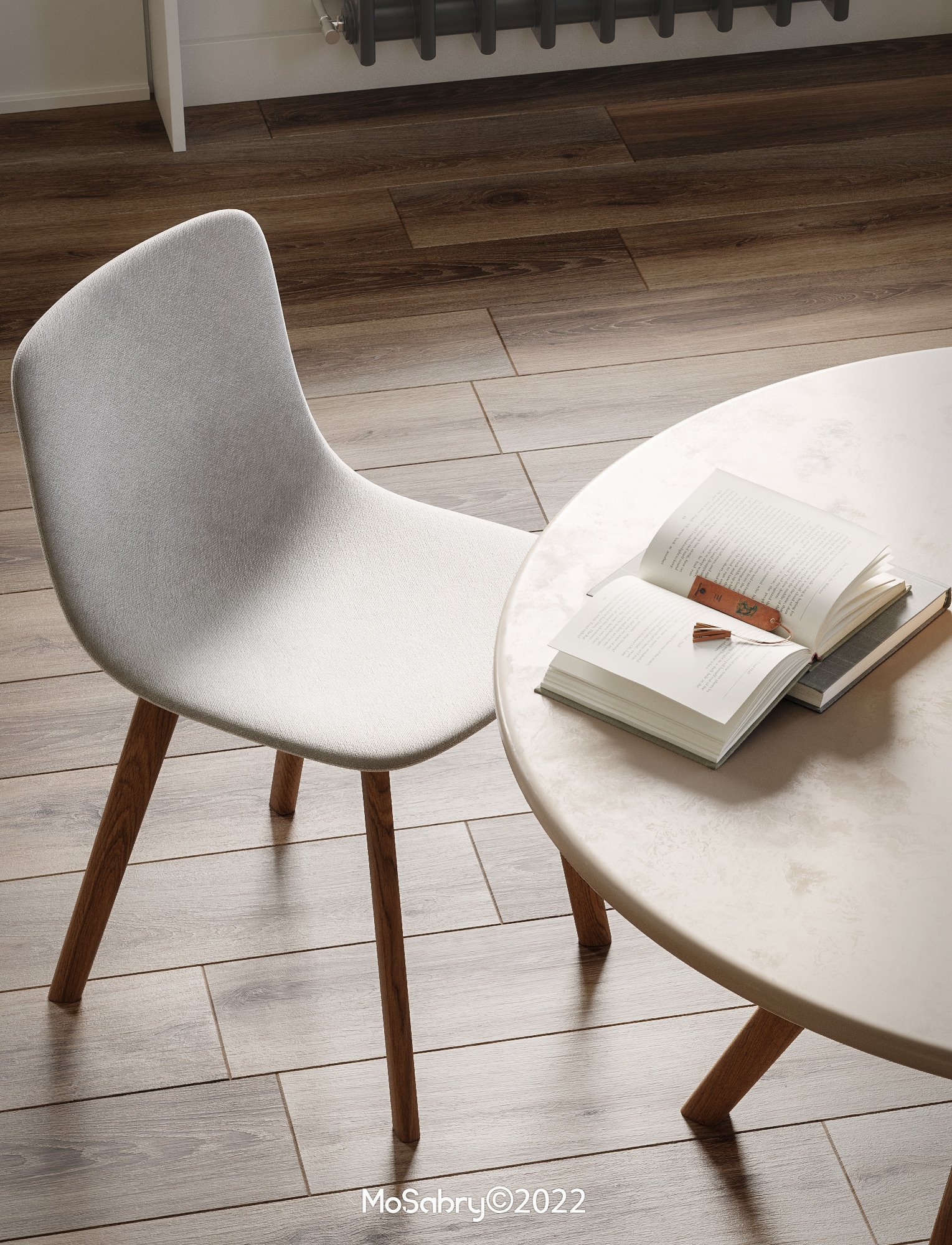 Upholstered chair beside a round marble table with an open book